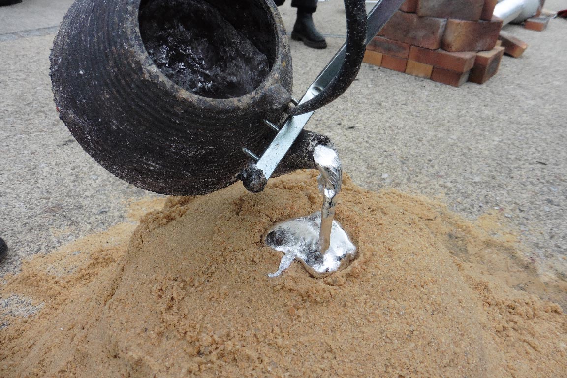 De l'aluminium fondu coule d'une théière