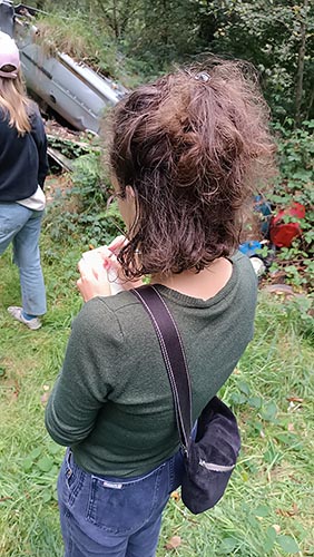 Une femme de dos qui écrit dans un carnet